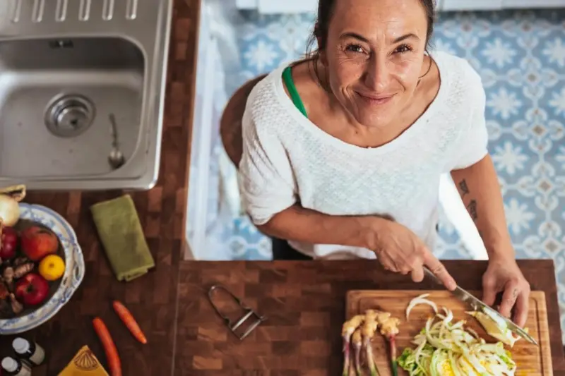 楽しそうに食事を作る女性の画像